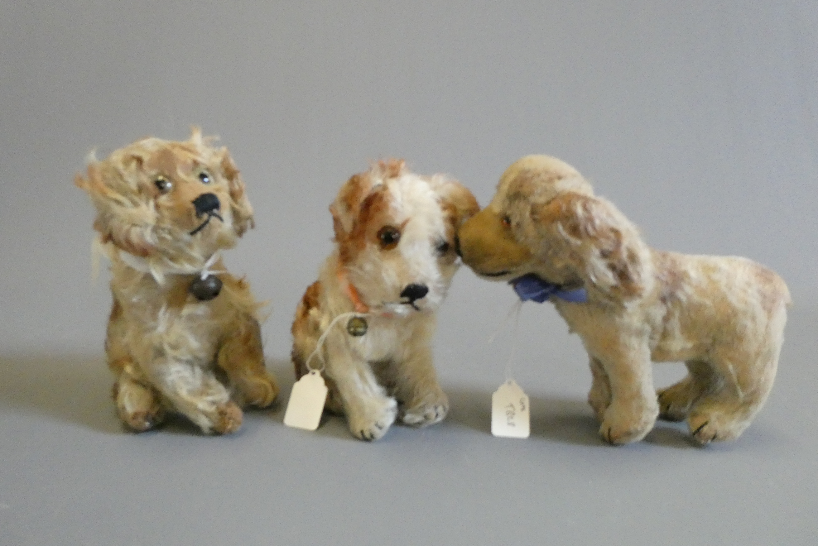 Three vintage plush dogs, including one with a Steiff button to its ear, others possibly by the same Image