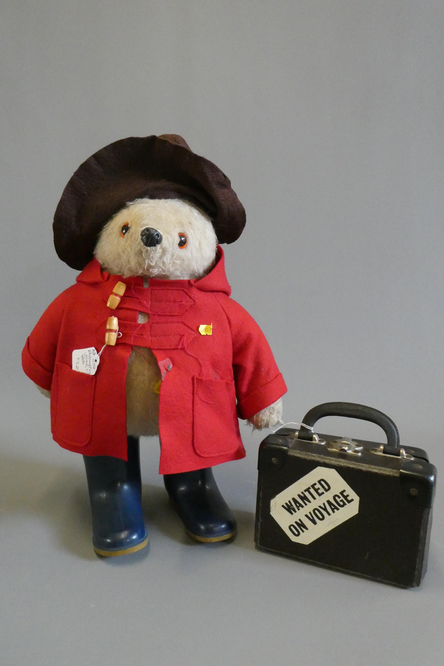 A vintage Paddington Bear, with red felt coat, brown felt hat, blue Dunlop boots, suitcase and Image