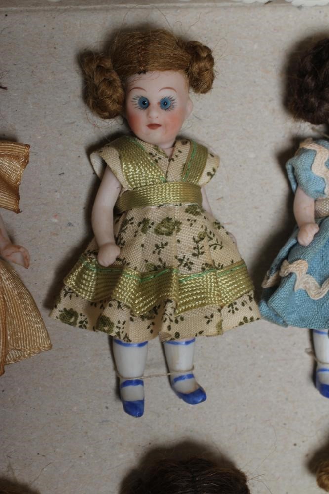 A boxed set of ten all bisque miniature dolls Image