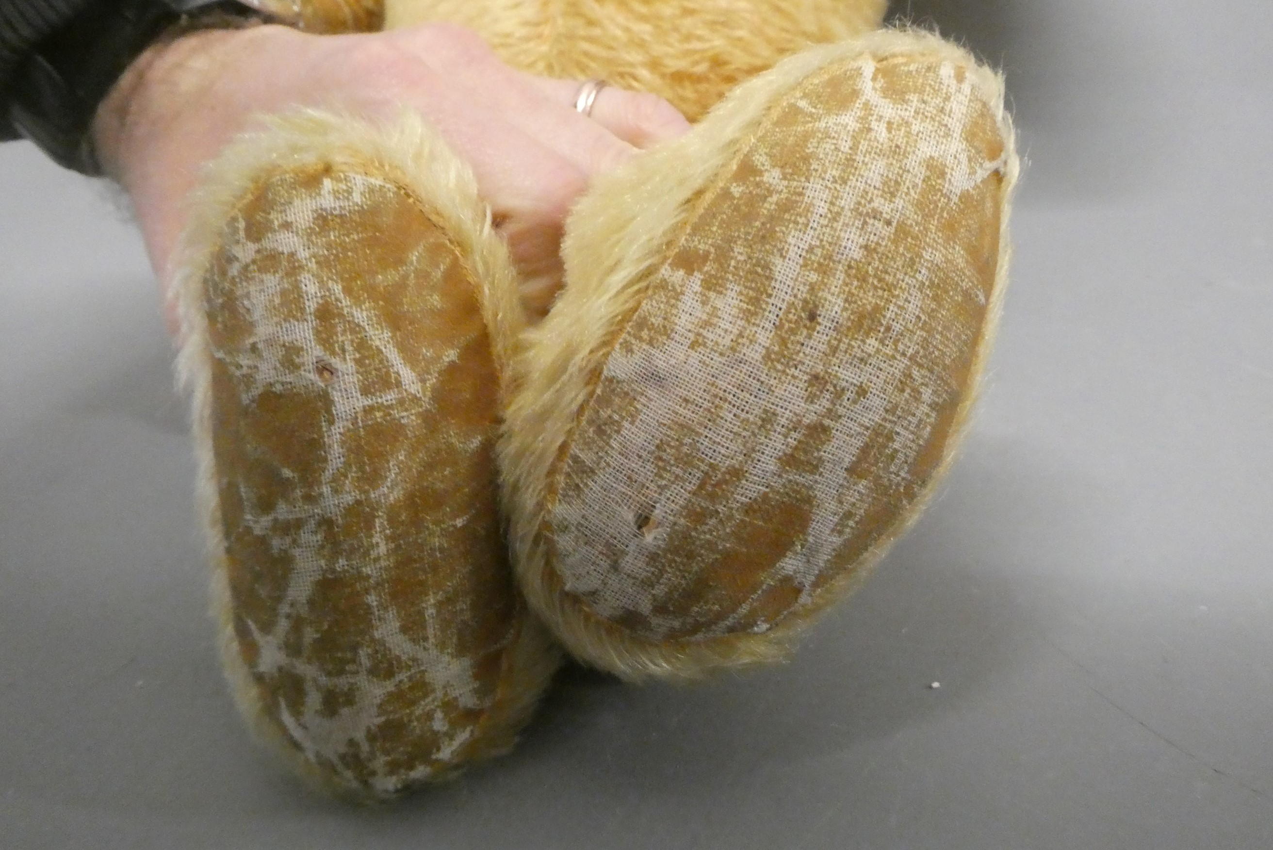 A 1950s orange plush teddy bear, with sewn nose and mouth, amber glass eyes and fabric pads, 30" Image