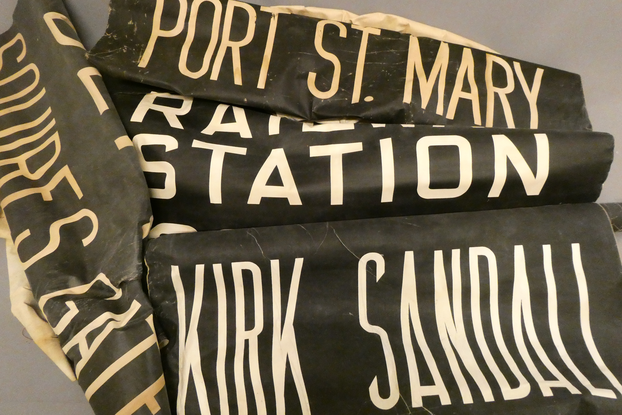 Three Bus destination rolls, white letters on black back ground, for various locations around the Image
