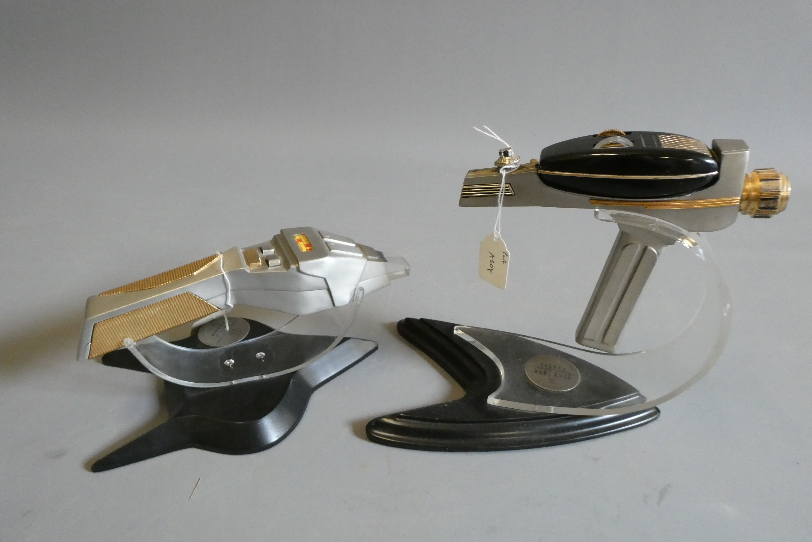 Star Trek - two Franklin Mint 30th anniversary phasers on stands, one with clear tip missing and Image