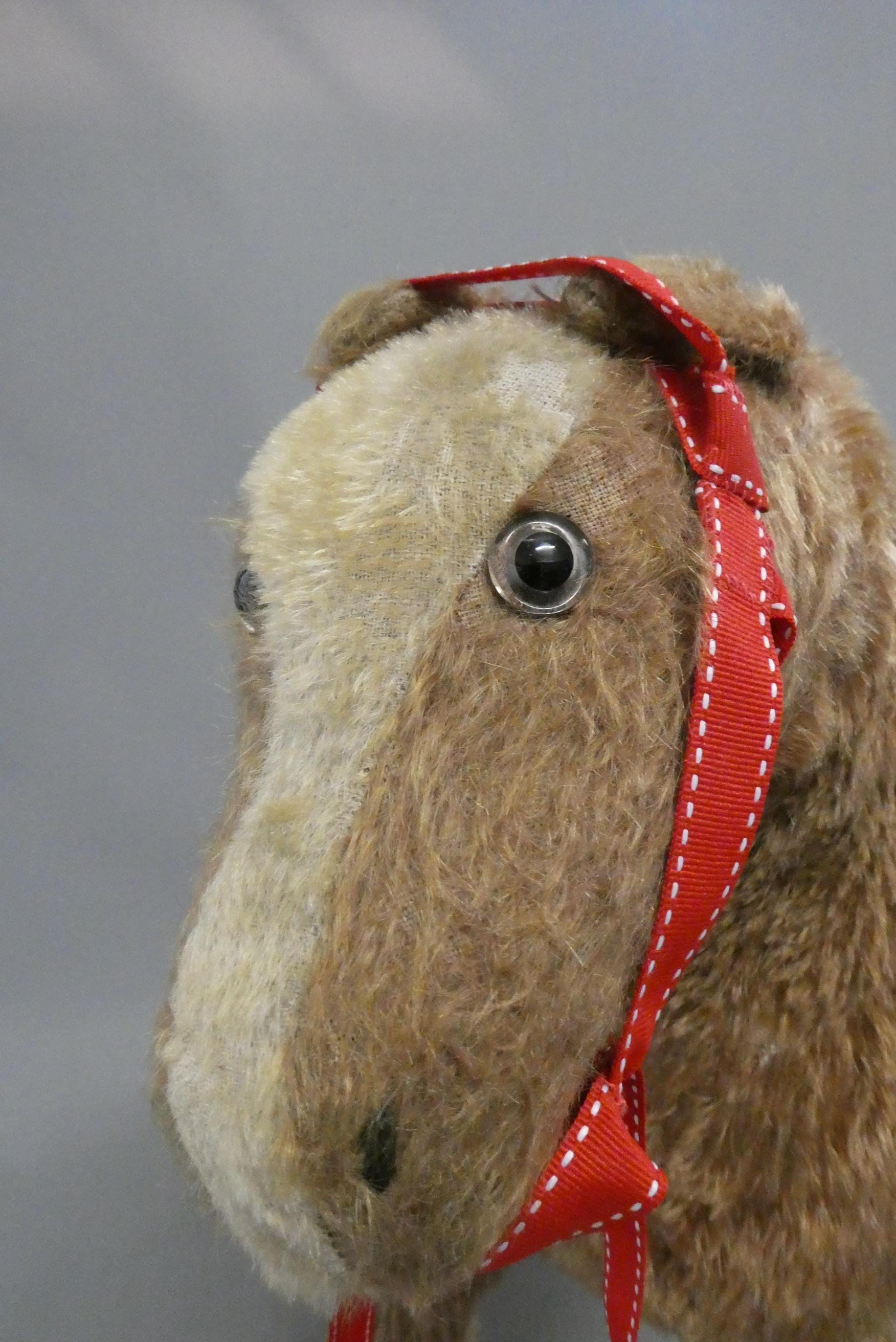 A vintage plush pull-a-long horse, with clear glass eyes and red metal frame with four wheels, 20" x Image