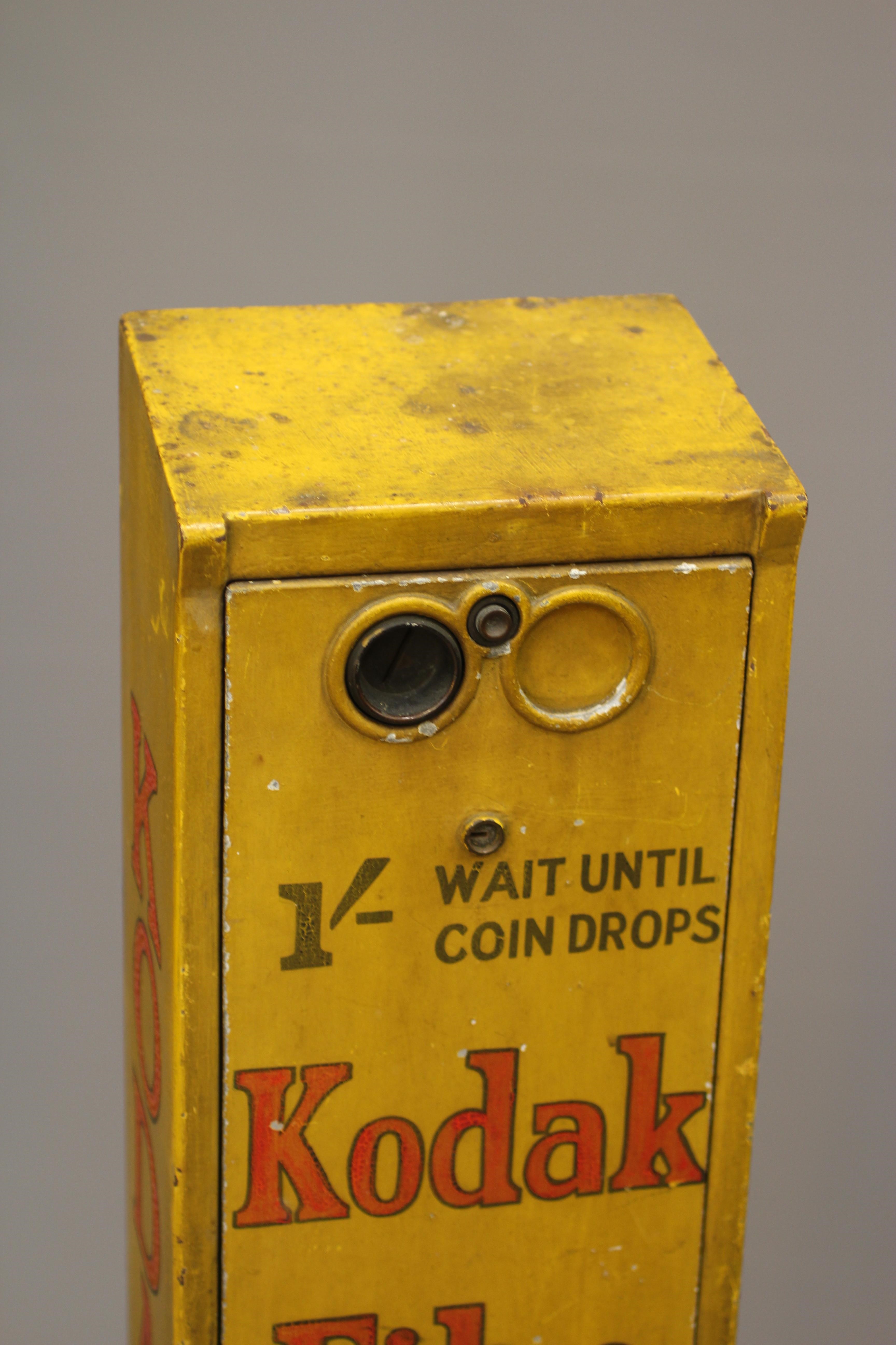 A Kodak film dispenser, 1940s, of metal construction painted yellow with red script, priced at 1/-, Image