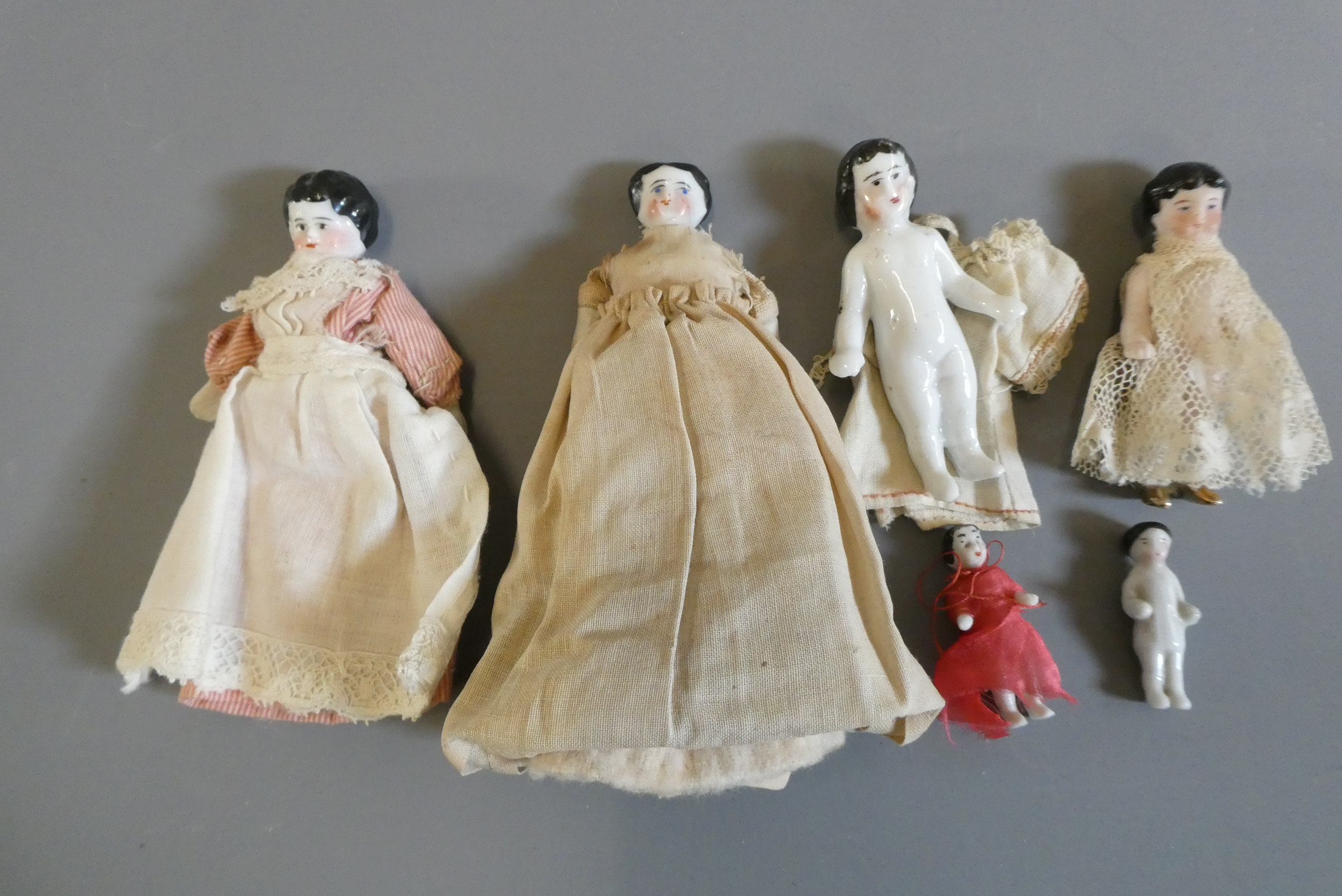 Six china doll's house dolls all with moulded and painted faces Image