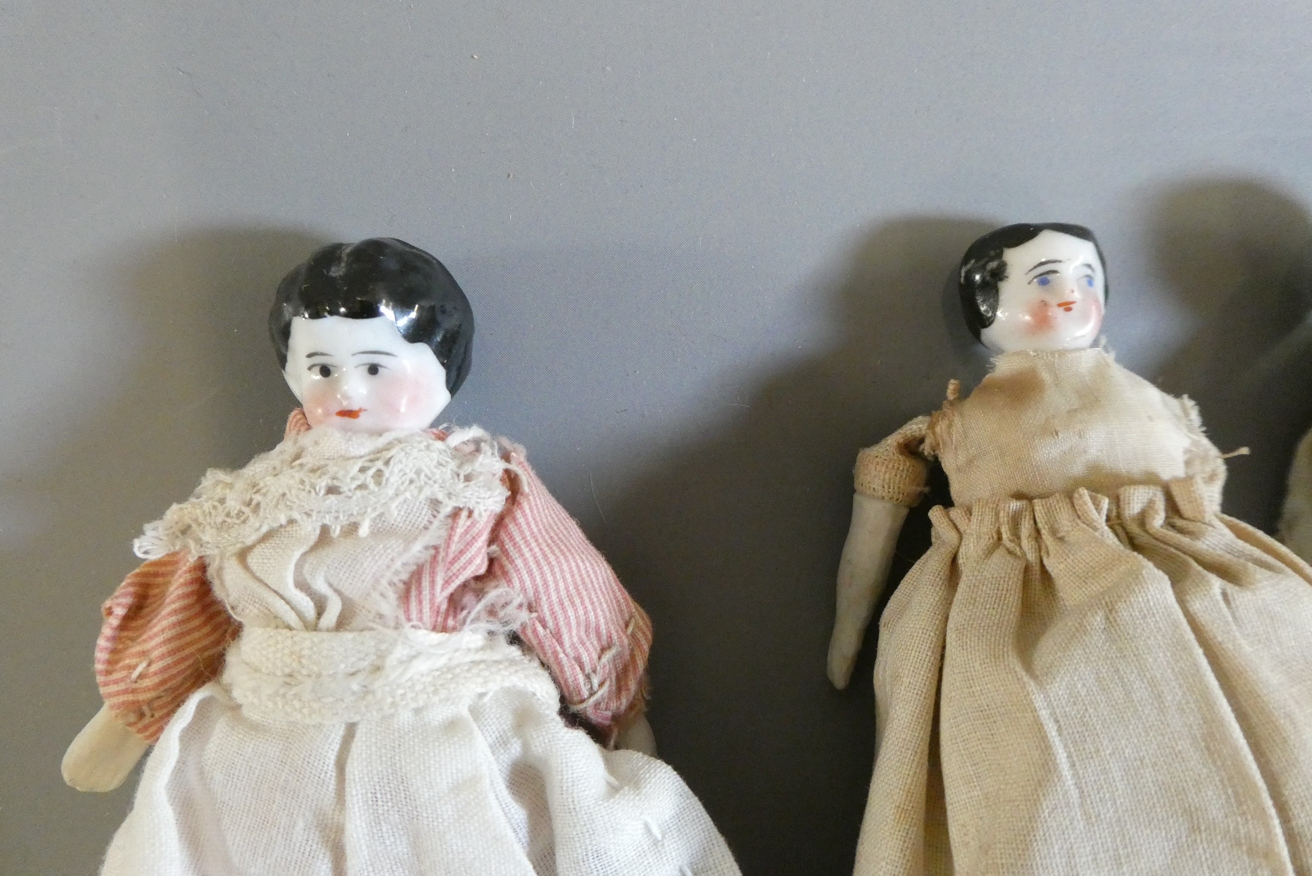 Six china doll's house dolls all with moulded and painted faces Image