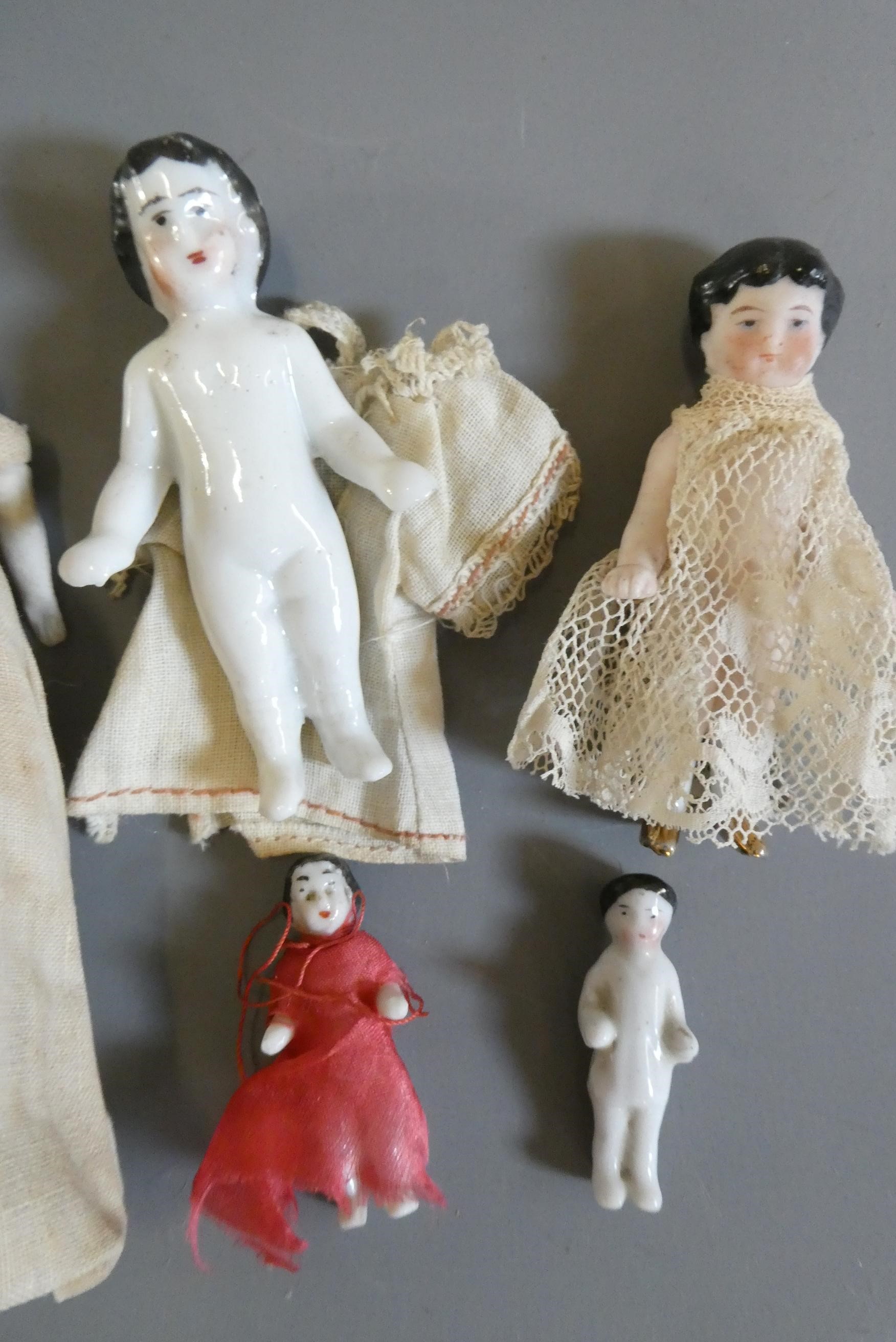 Six china doll's house dolls all with moulded and painted faces Image