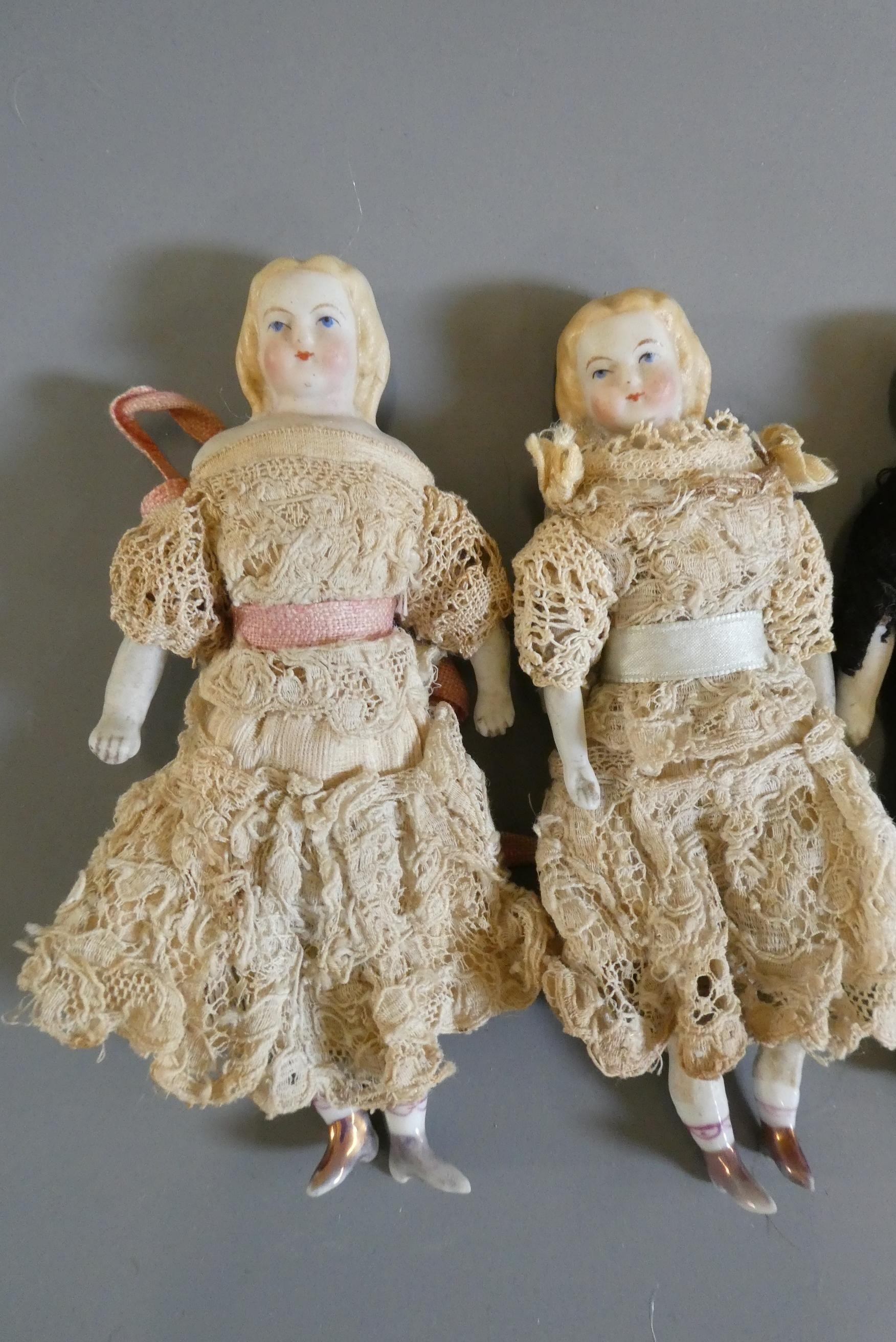 A pair of bisque shoulder head dolls with moulded and painted features Image