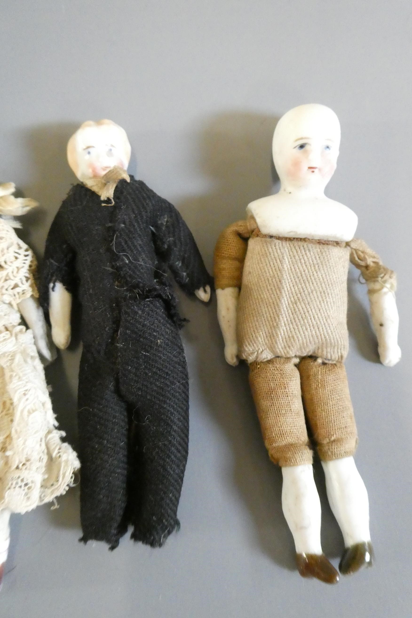 A pair of bisque shoulder head dolls with moulded and painted features Image