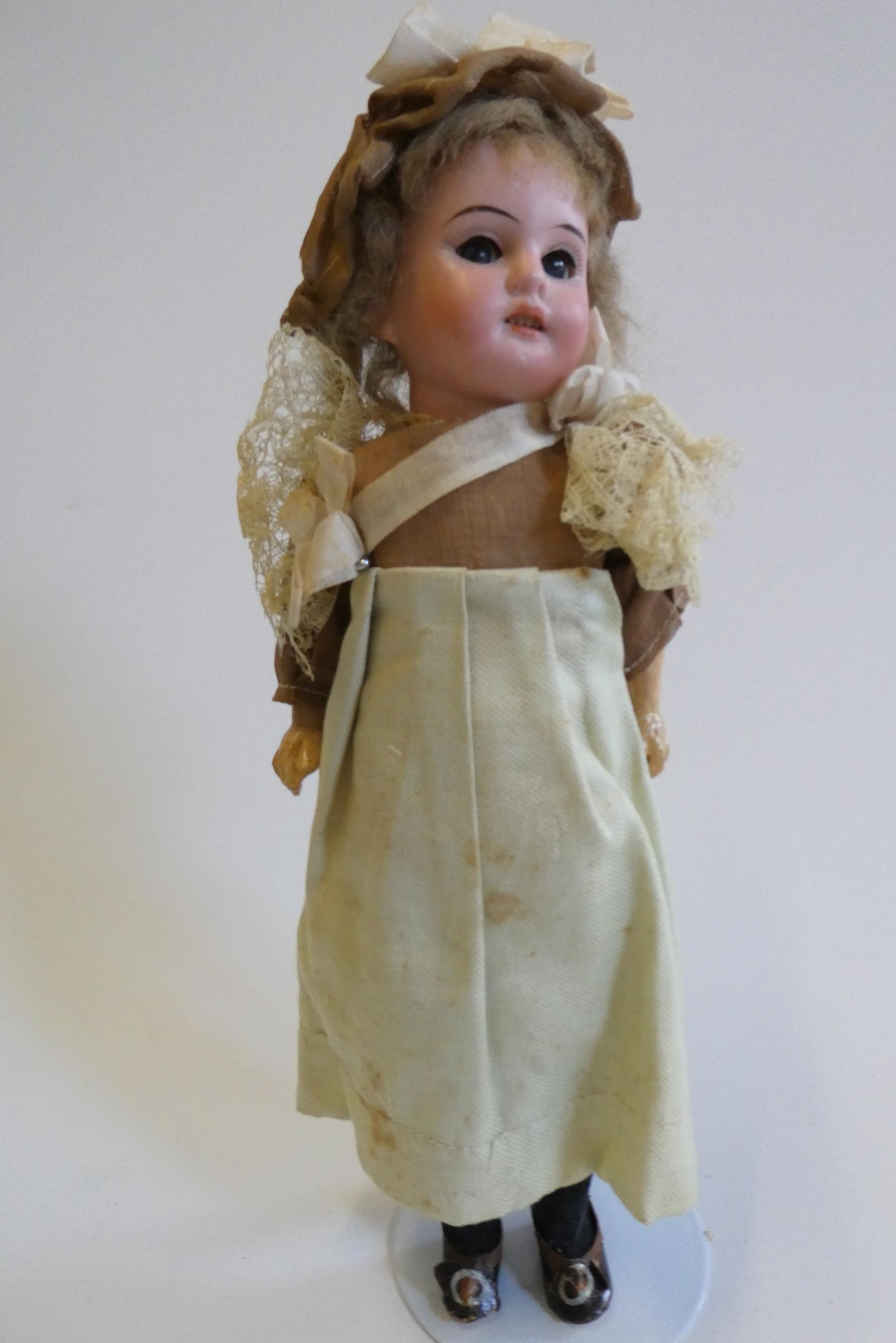 An Armand Marseille bisque socket head doll with blue glass sleeping eyes Image
