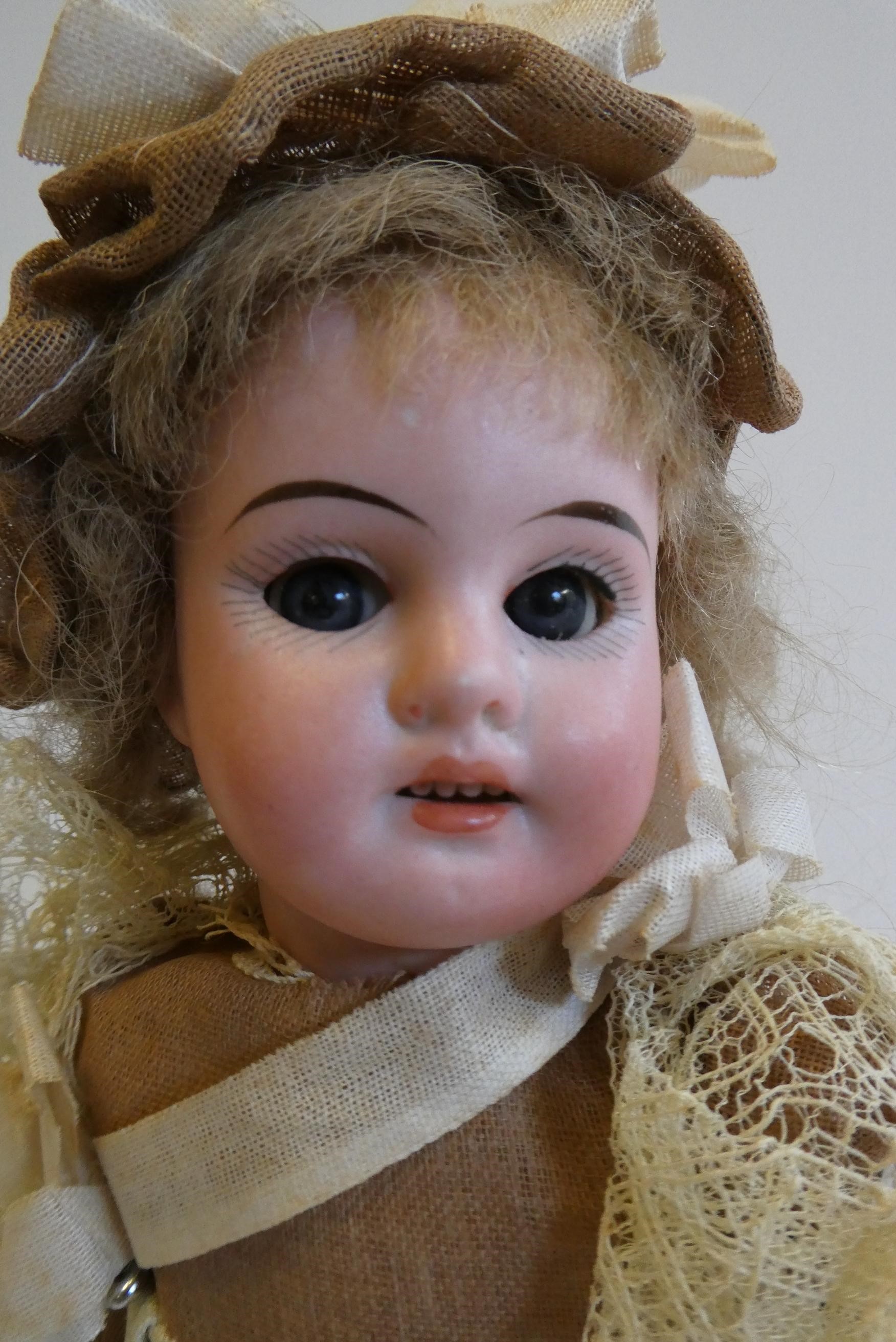An Armand Marseille bisque socket head doll with blue glass sleeping eyes Image