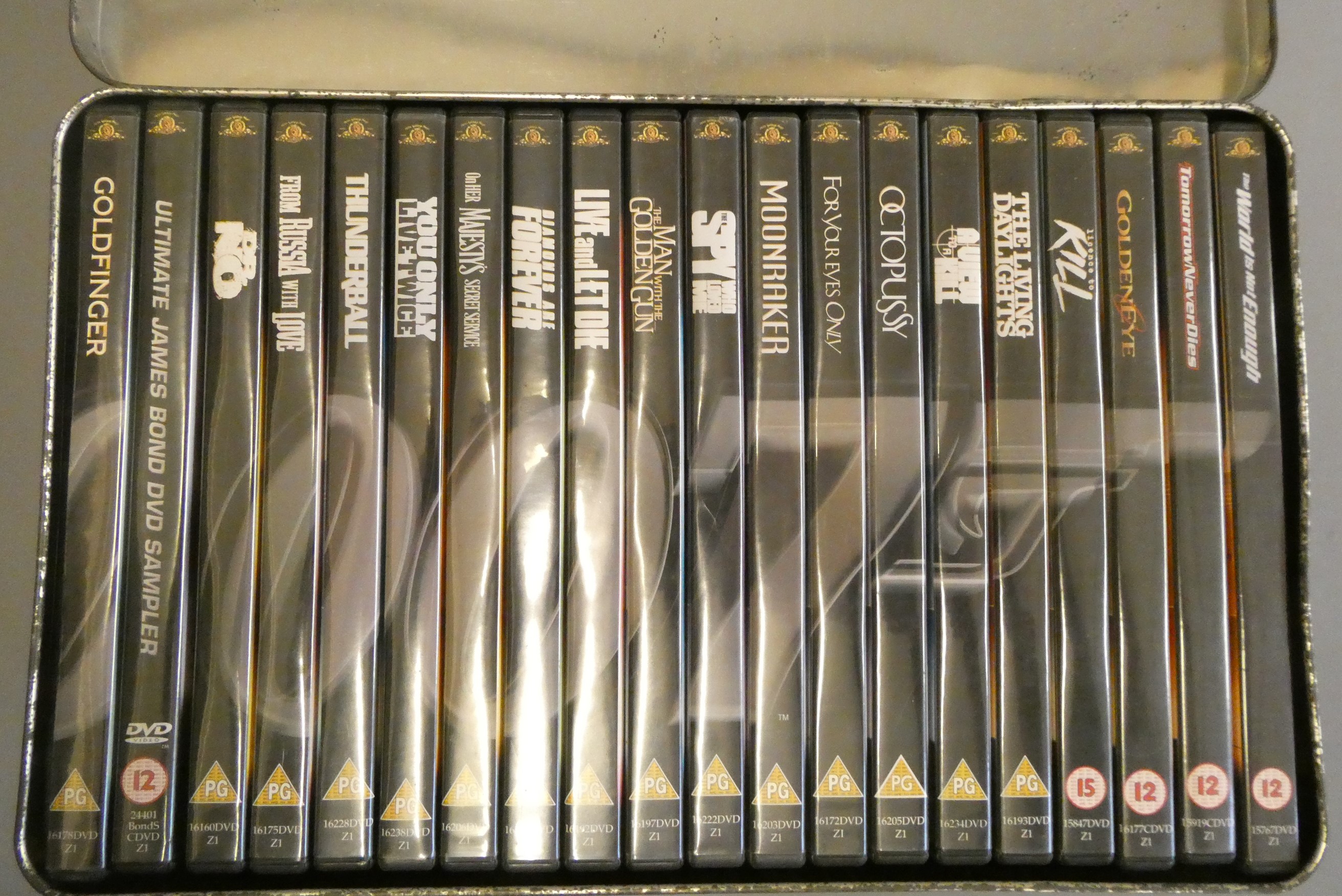 Twenty James Bonds film dvds in 007 embossed tin box (some rusting to box), unchecked for Image