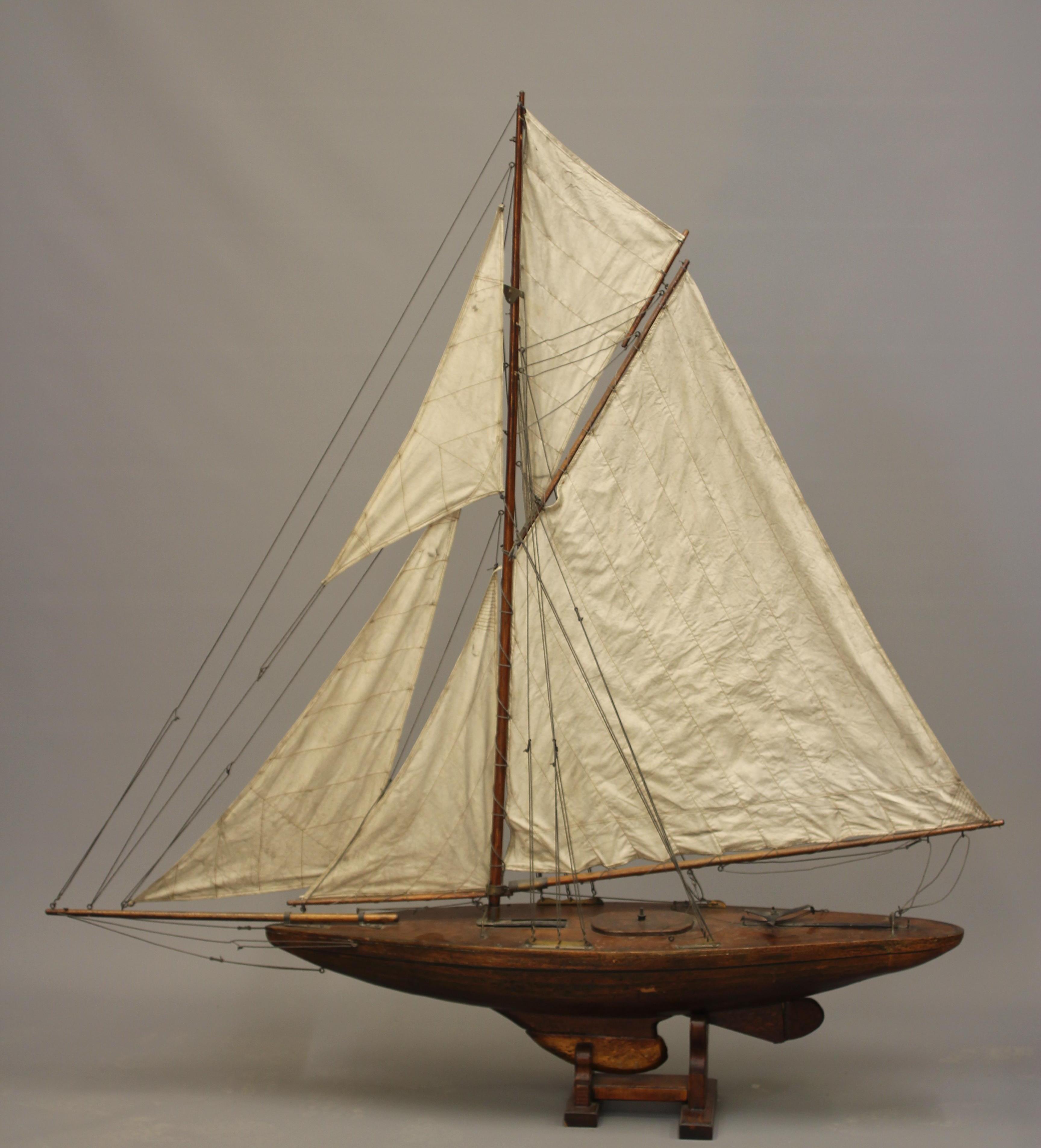 A wooden yacht model fitted with main sail Image