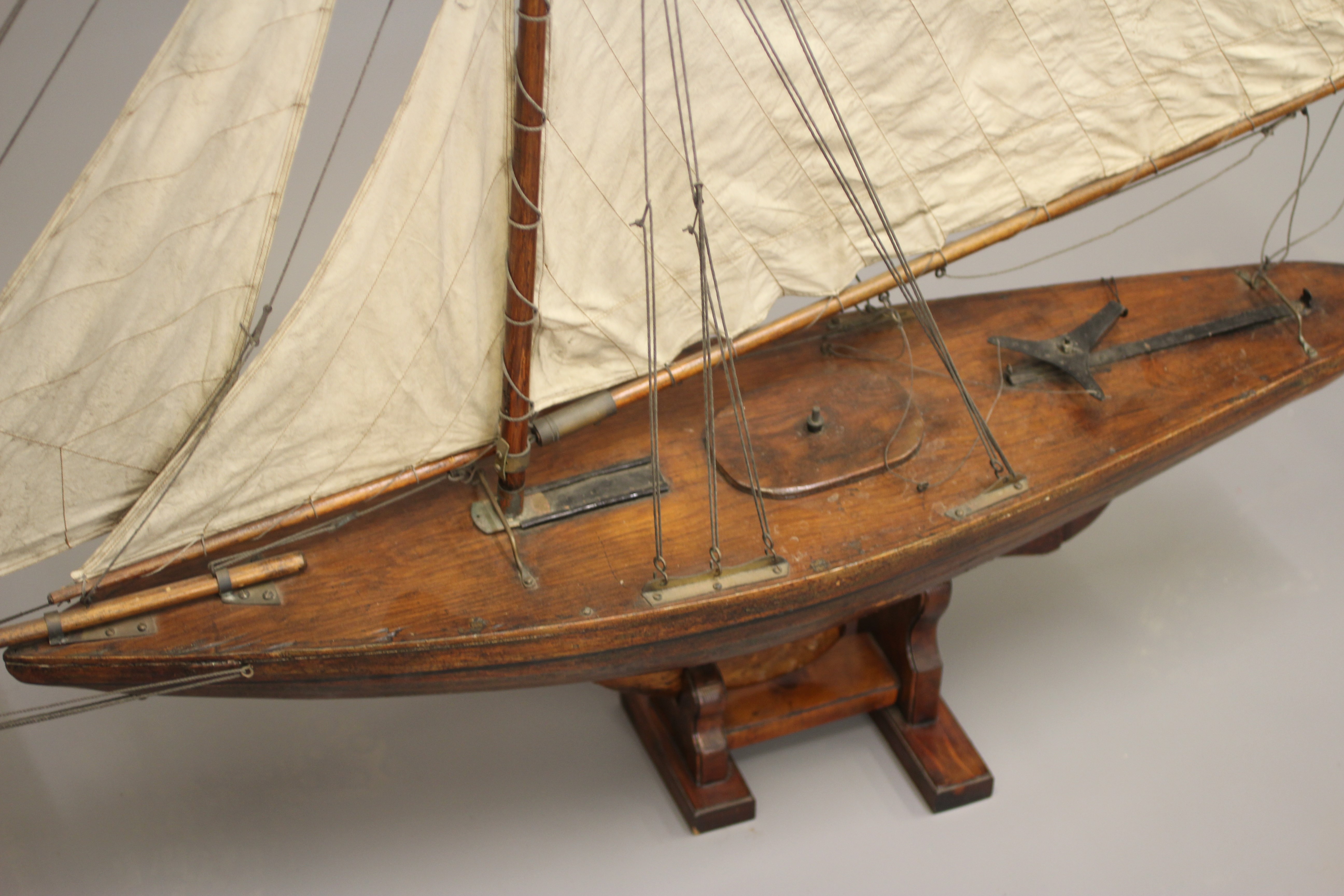 A wooden yacht model fitted with main sail Image