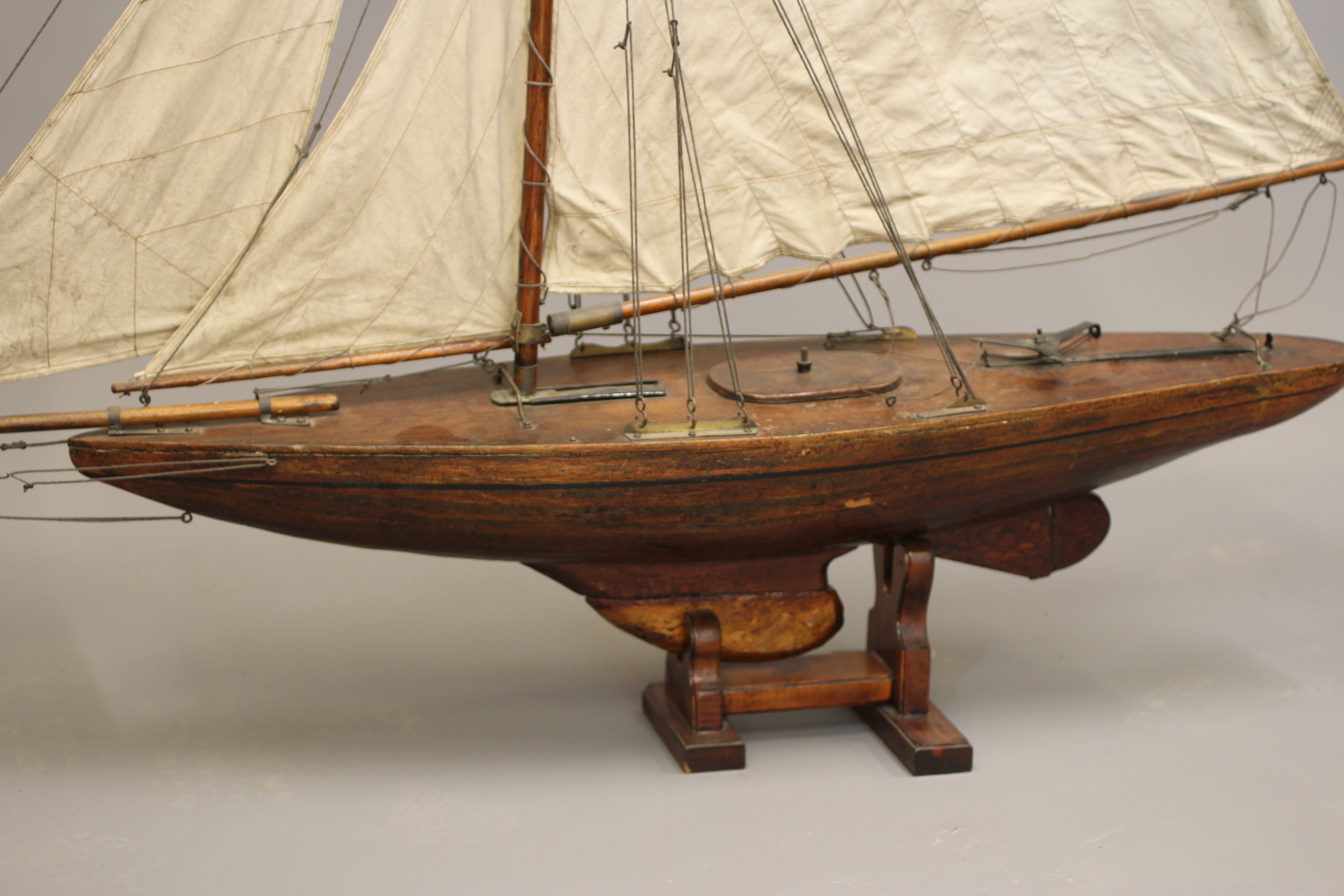 A wooden yacht model fitted with main sail Image