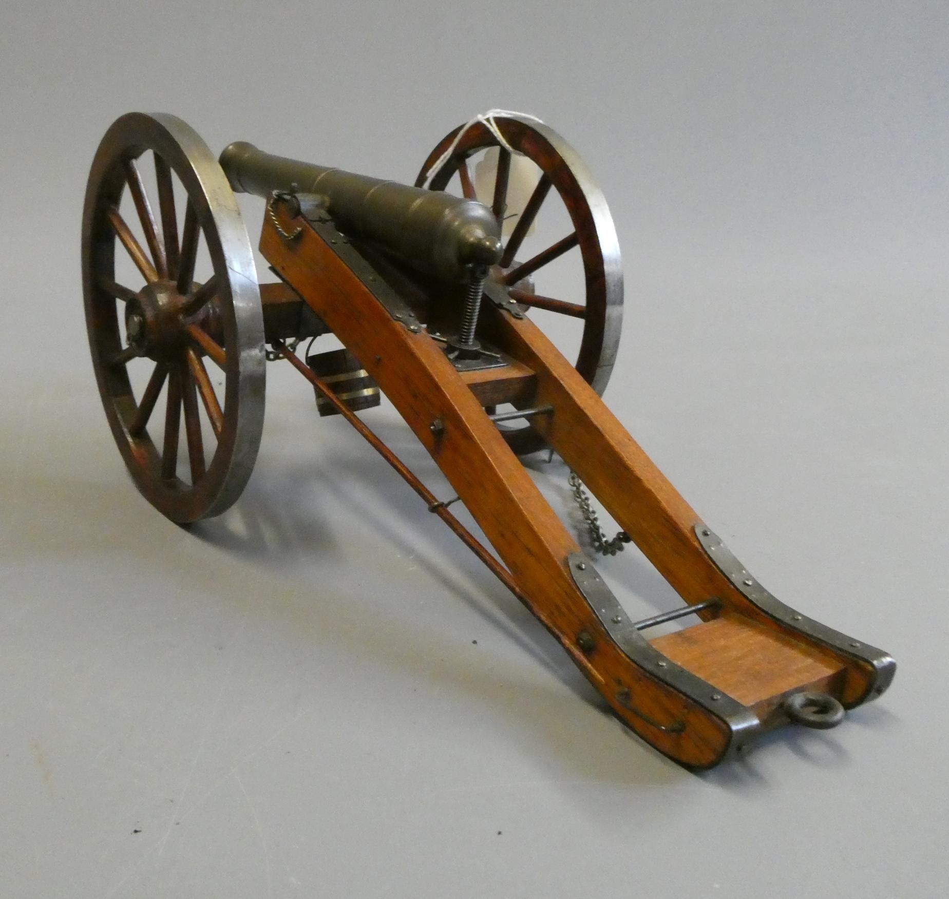 A well-made wooden and brass field gun, mounted on trolley with spoked wooden wheels, brass cannon Image