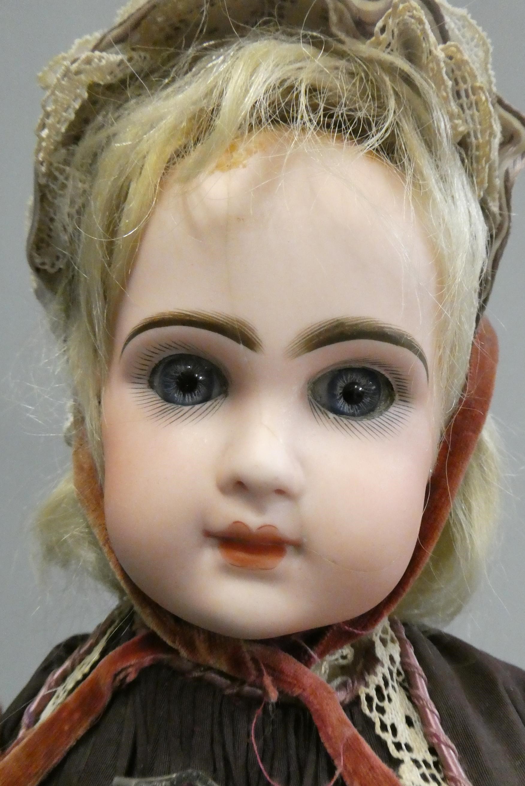 A Tete Jumeau bisque socket head doll with blue glass fixed eyes Image
