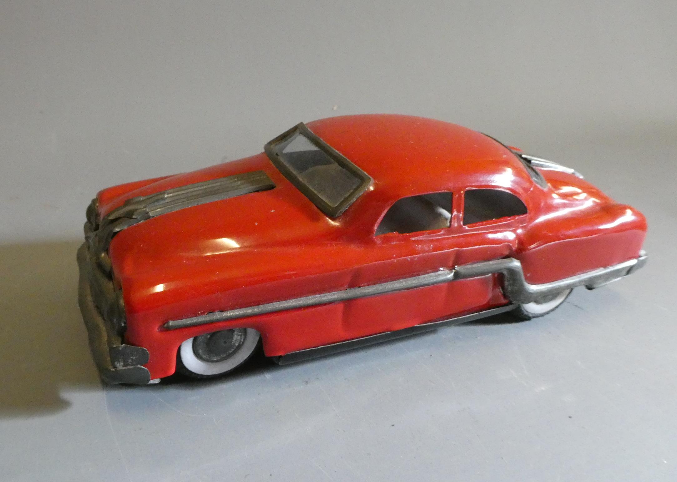 Friction powered American style saloon car finished in red. Some age wear to plated parts. Fair Image