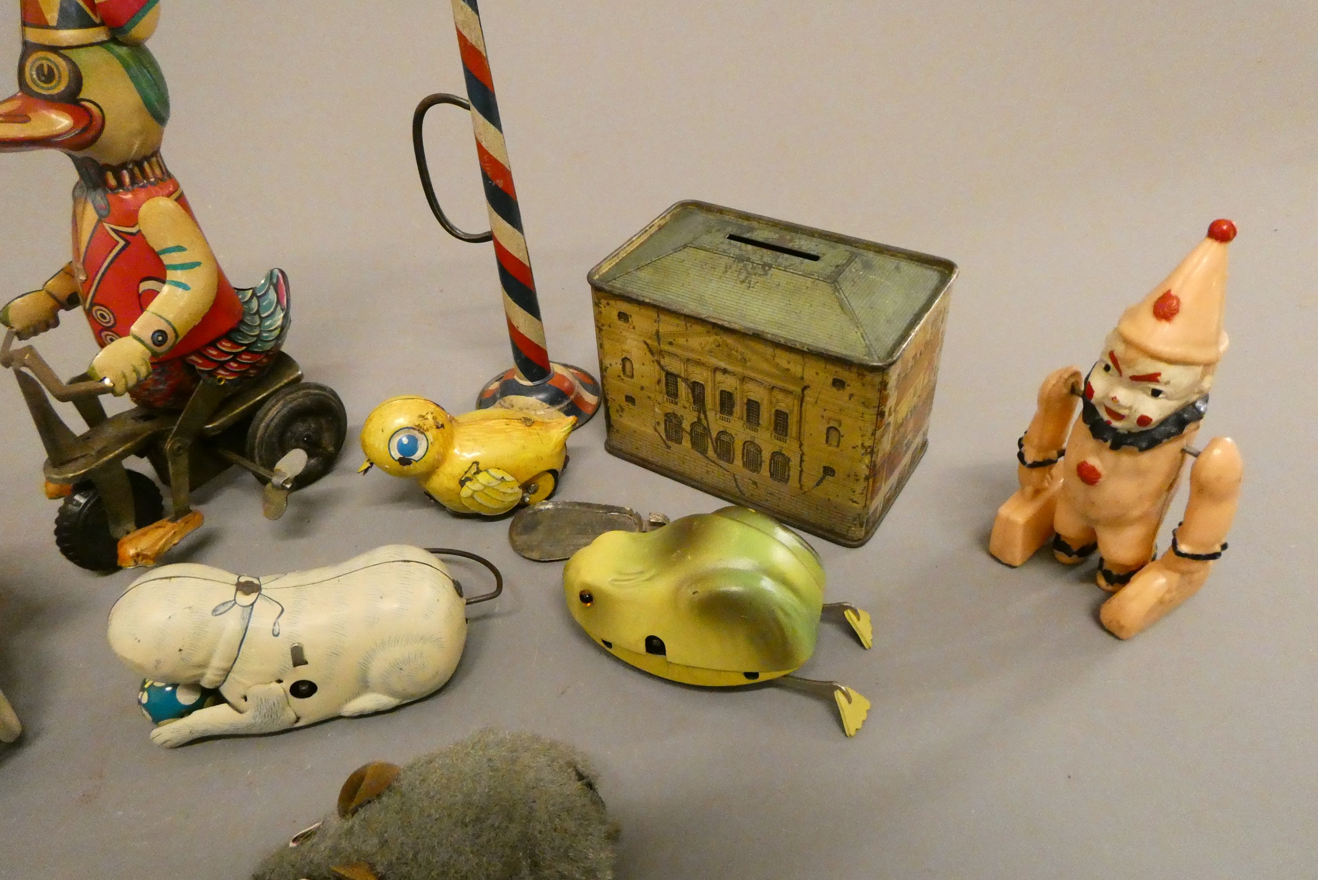 An assortment of tinplate and plastic novelty animal toys and tin money box, fair (Est. plus 24% Image