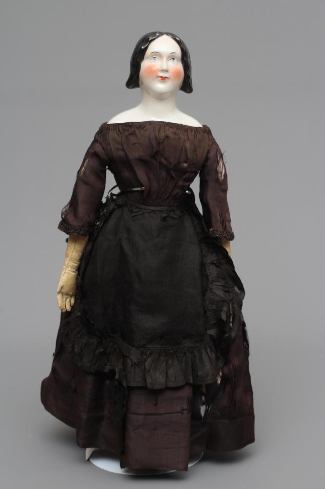 A Victorian china shoulder head doll, with painted face, well moulded hair, fabric body, kid lower Image