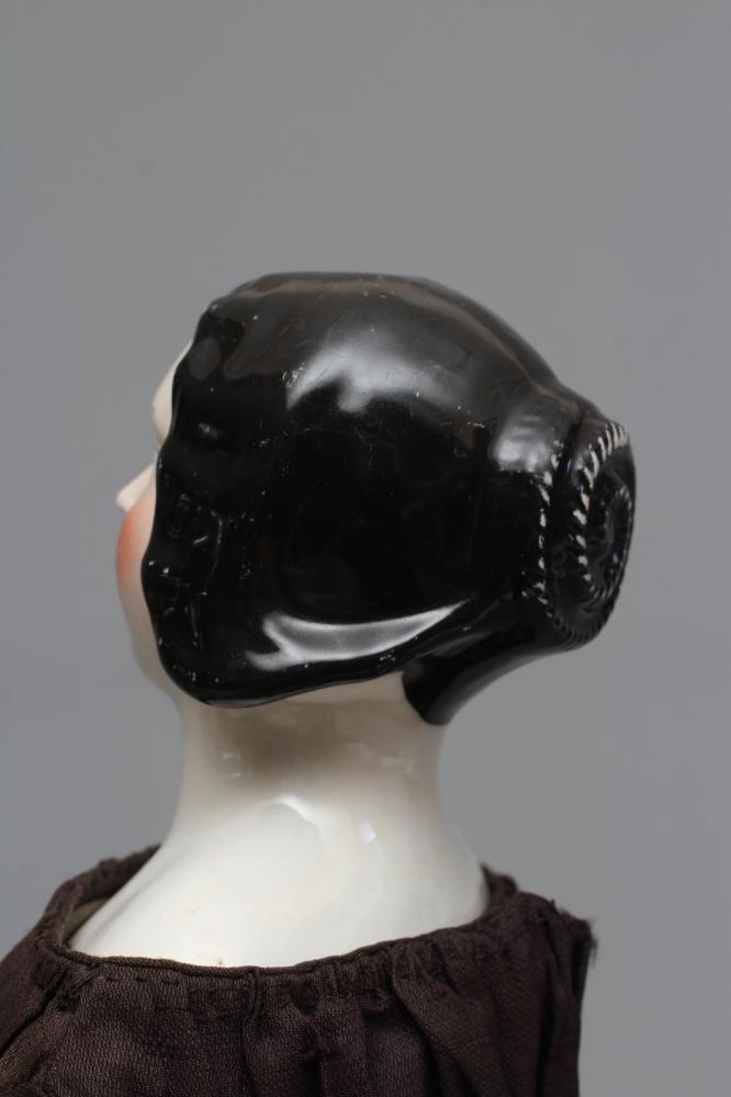 A Victorian china shoulder head doll, with painted face, well moulded hair, fabric body, kid lower Image