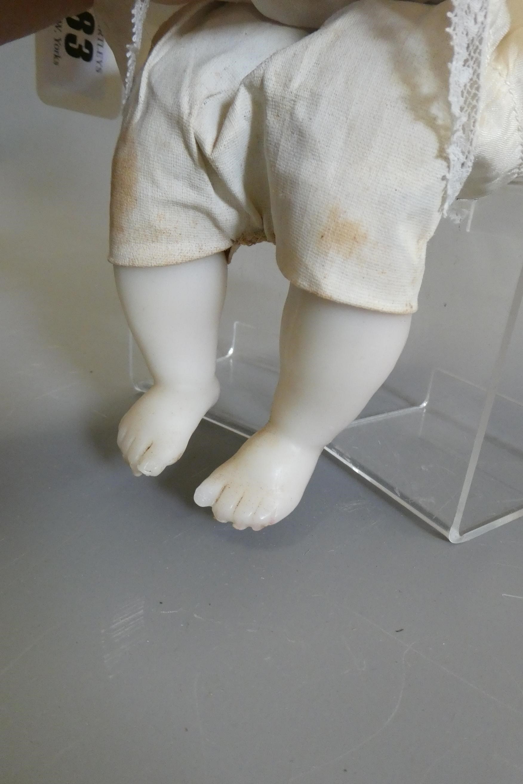 A seated wax shoulder head doll, with blue glass fixed eyes, open mouth, teeth, blond wig, fabric Image