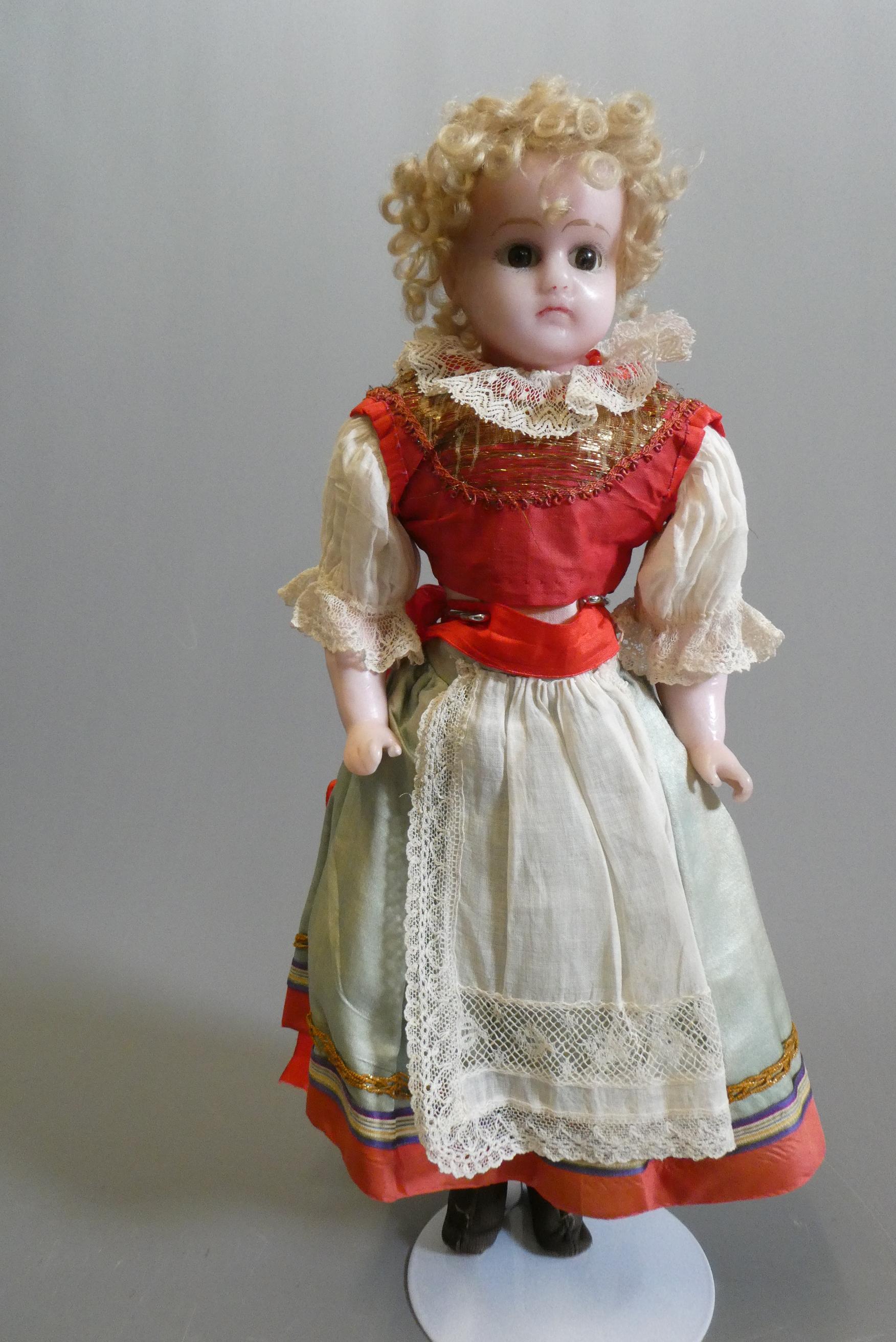 A Victorian wax shoulder head doll, with brown glass sleeping eyes, closed mouth, blond wig, fabric Image