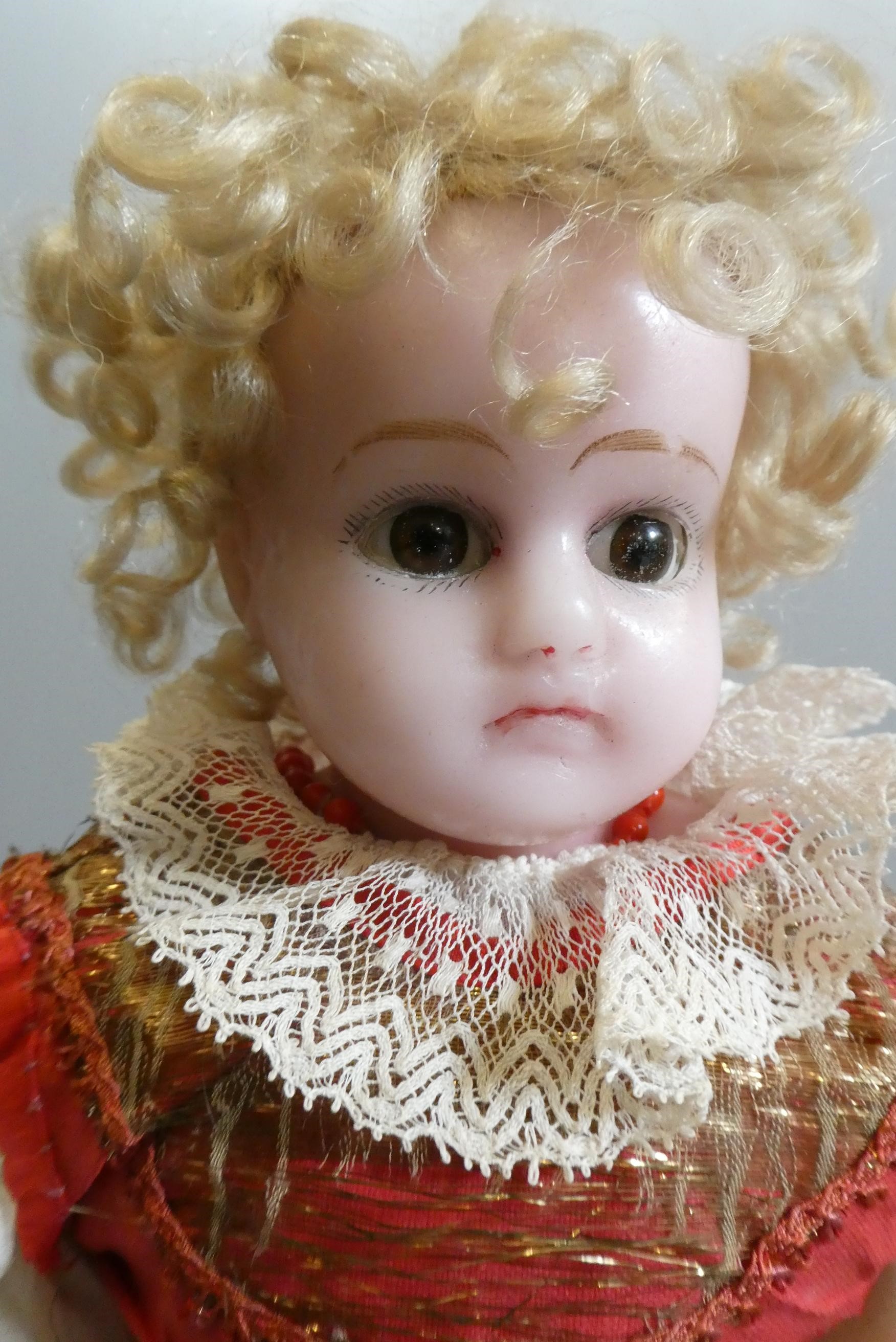 A Victorian wax shoulder head doll, with brown glass sleeping eyes, closed mouth, blond wig, fabric Image