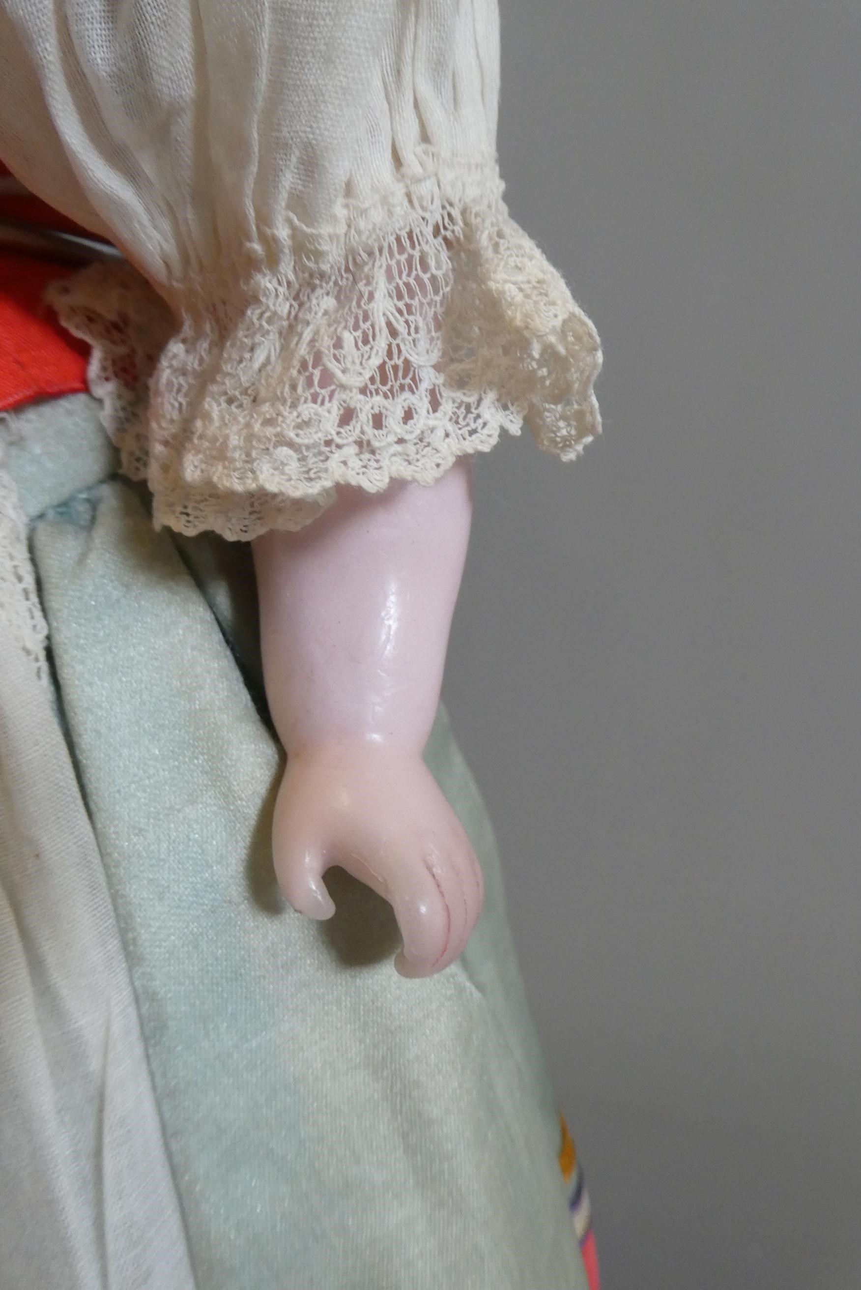 A Victorian wax shoulder head doll, with brown glass sleeping eyes, closed mouth, blond wig, fabric Image