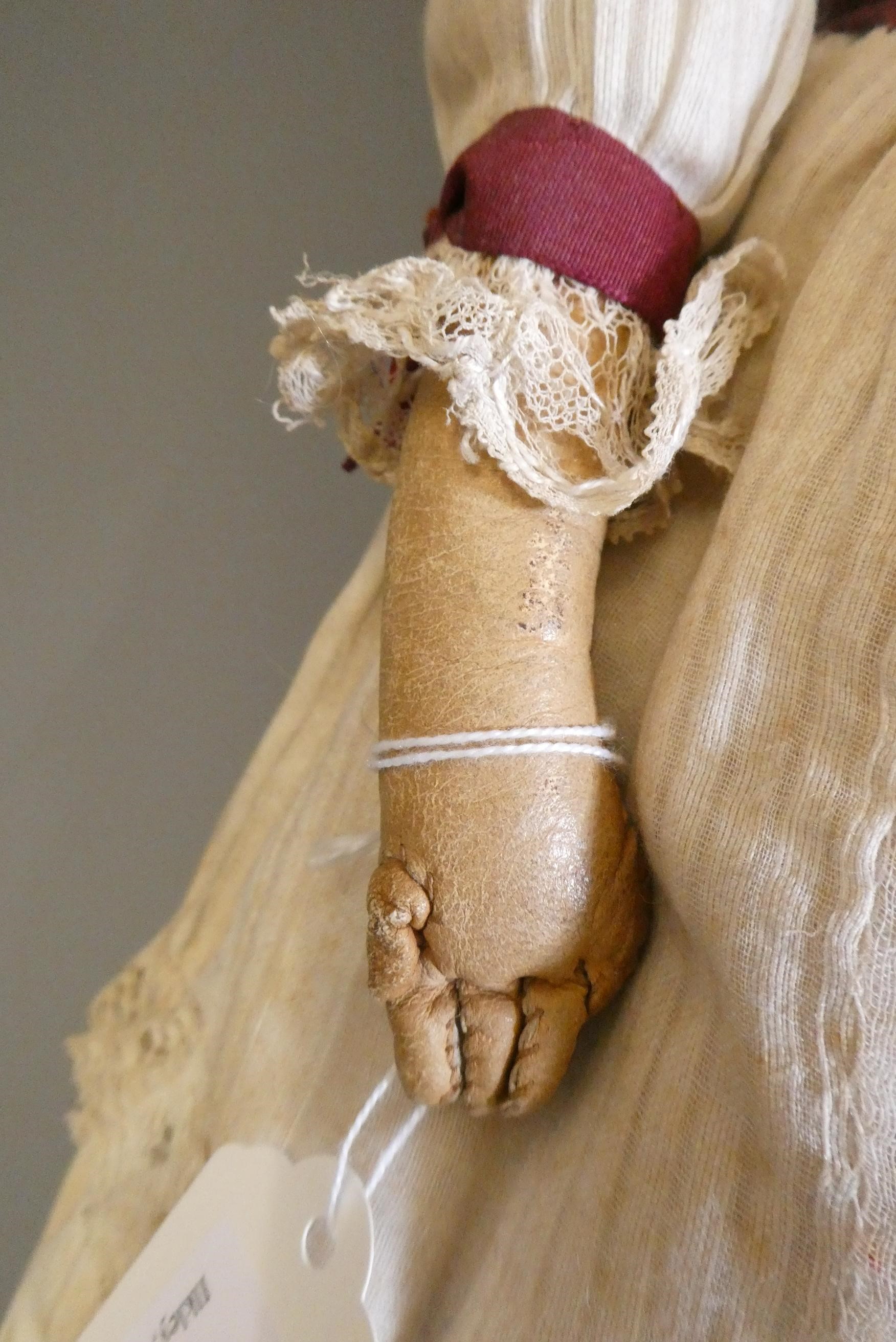 A Victorian wax shoulder head doll, with brown glass fixed eyes, closed mouth, blond wig, fabric Image