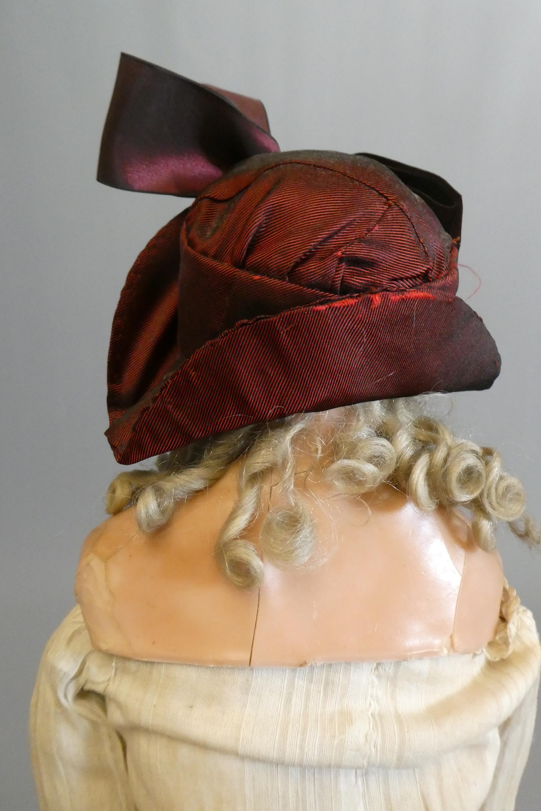 A Victorian wax shoulder head doll, with brown glass fixed eyes, closed mouth, blond wig, fabric Image
