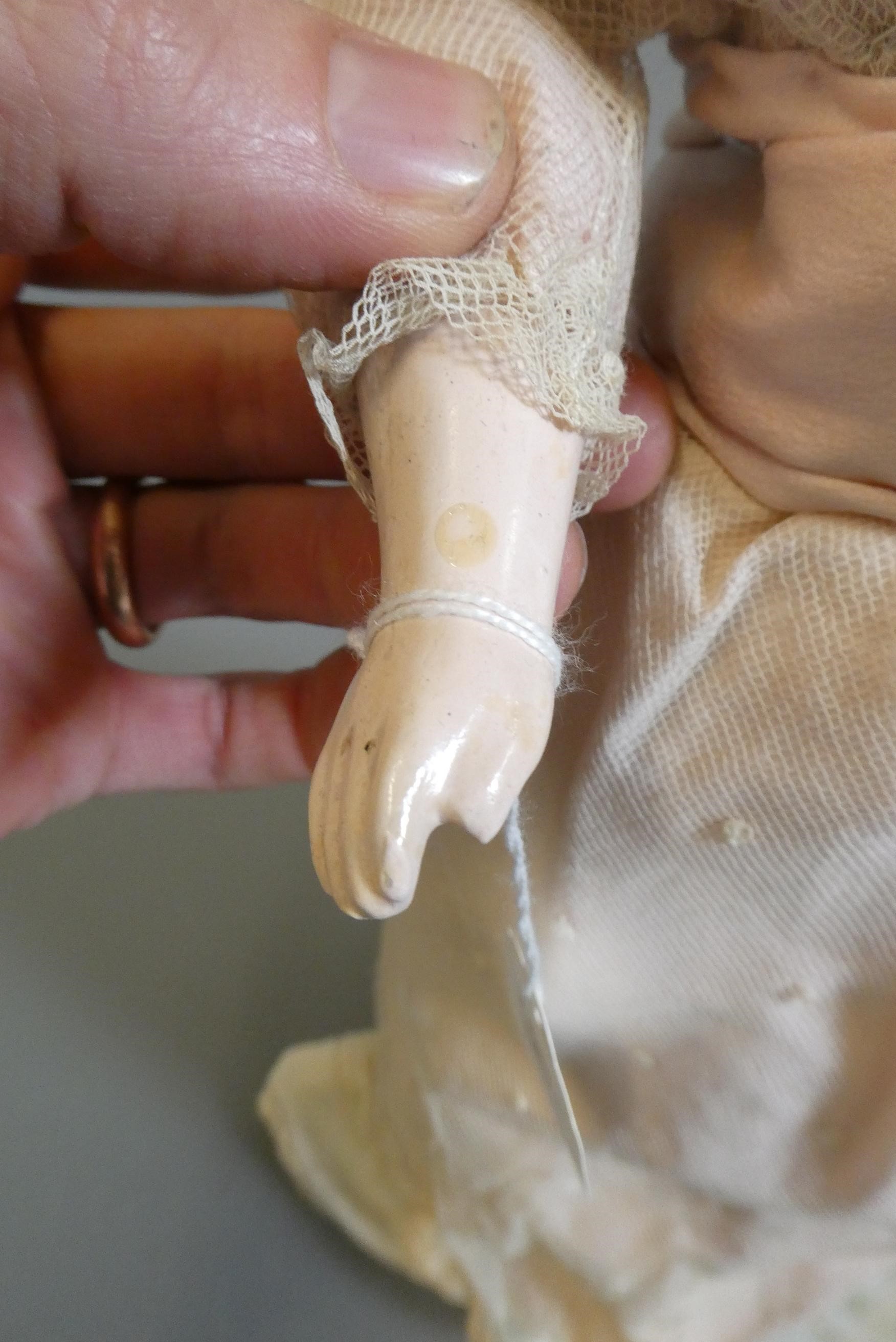 A late Victorian wax shoulder head doll, with blue glass fixed eyes, closed mouth, blond wig, fabric Image