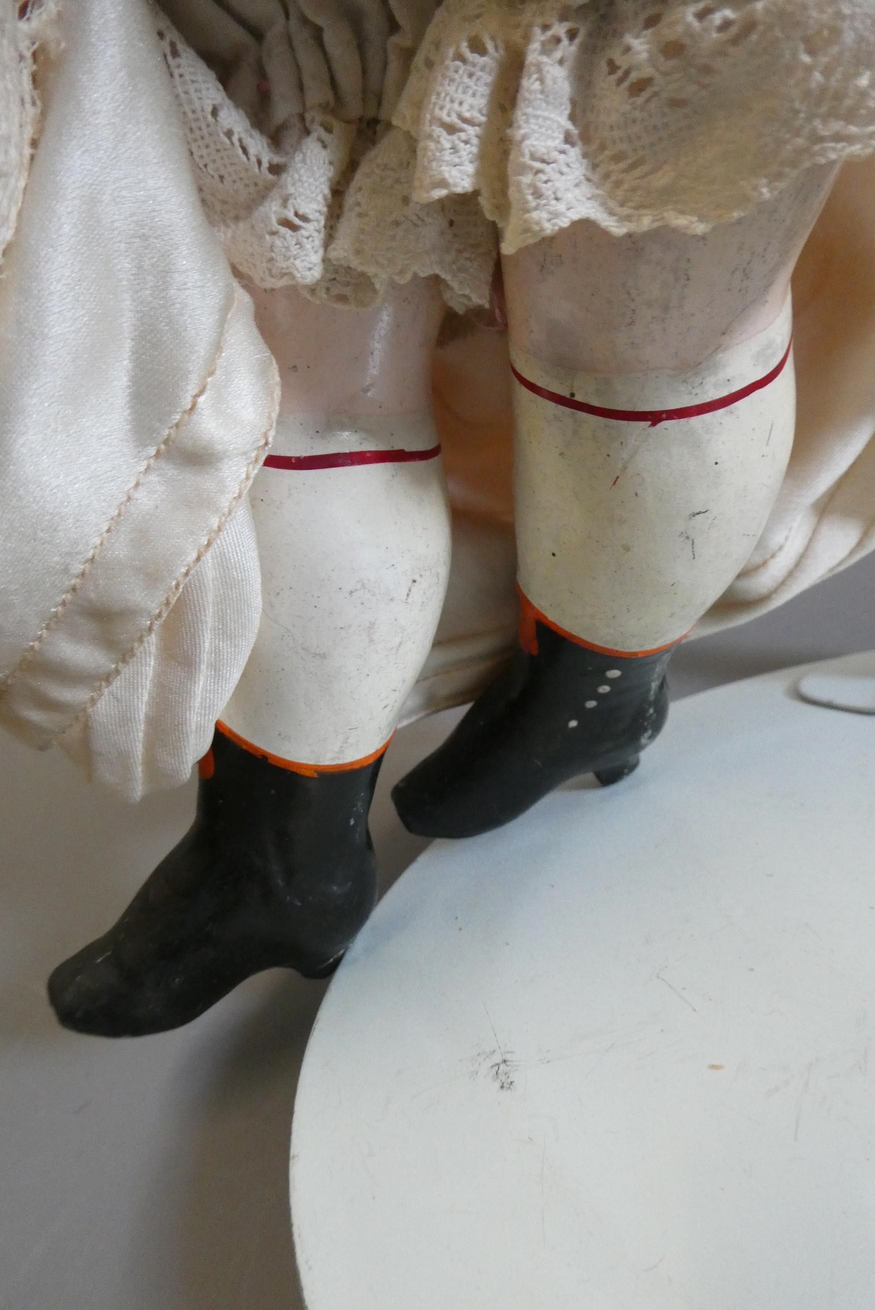 A late Victorian wax shoulder head doll, with blue glass fixed eyes, closed mouth, blond wig, fabric Image
