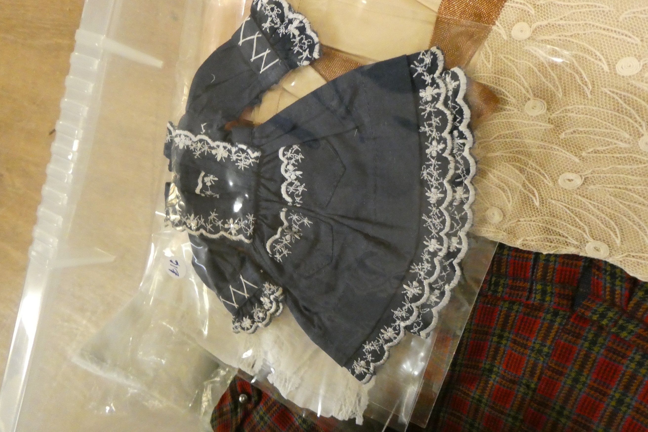 Three boxes of doll's clothing, including antique examples, lace, bonnets and much more (Est. plus Image