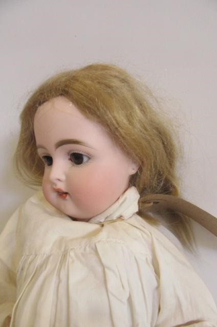 A Kammer & Reinhardt bisque head doll with brown glass sleeping eyes Image