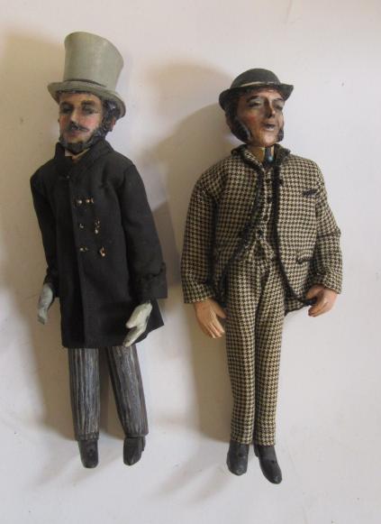 Two painted and dressed cased wood male dolls Image