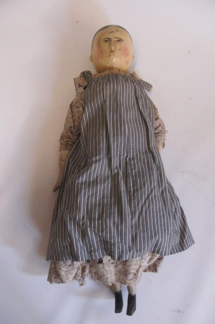 A carved and painted wooden doll Image