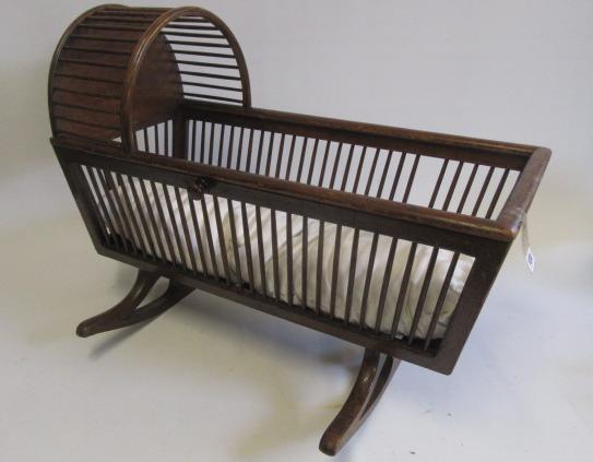 A doll's mahogany finish cradle with arched top Image