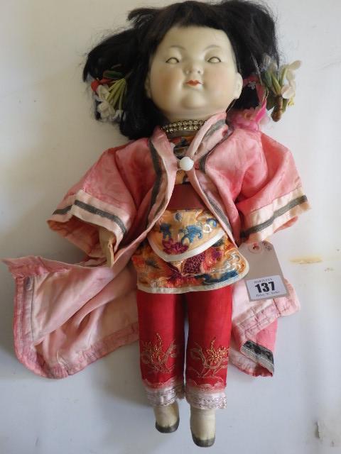 An Armand Marseille bisque socket head Oriental doll with brown glass sleeping eyes and painted face Image