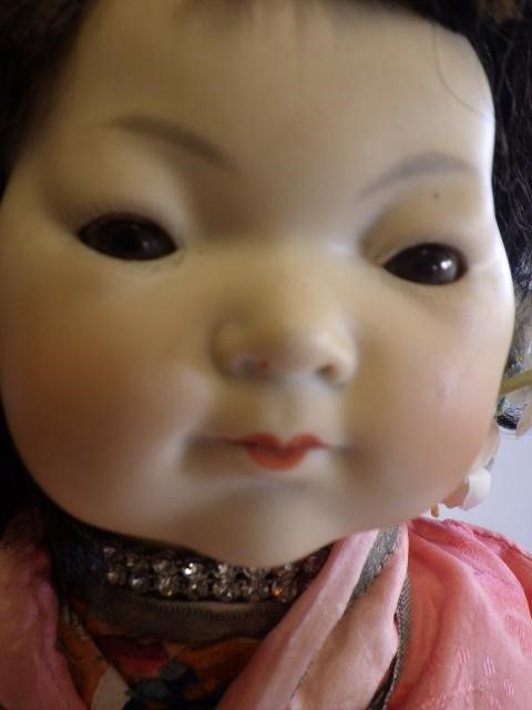 An Armand Marseille bisque socket head Oriental doll with brown glass sleeping eyes and painted face Image
