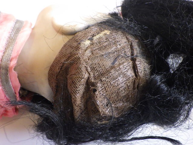 An Armand Marseille bisque socket head Oriental doll with brown glass sleeping eyes and painted face Image