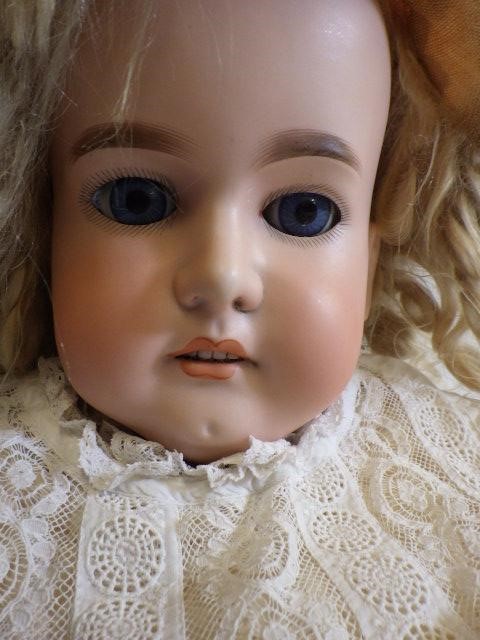 A large Armand Marseille bisque head and shoulders doll with fixed blue glass eyes Image