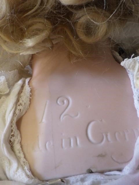 A large Armand Marseille bisque head and shoulders doll with fixed blue glass eyes Image