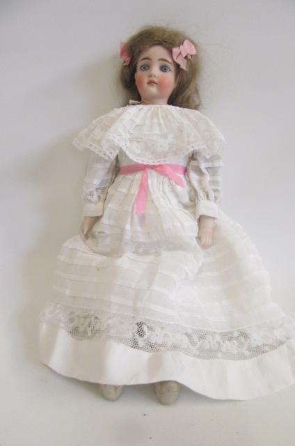 A bisque shoulder head doll with fixed blue glass eyes Image