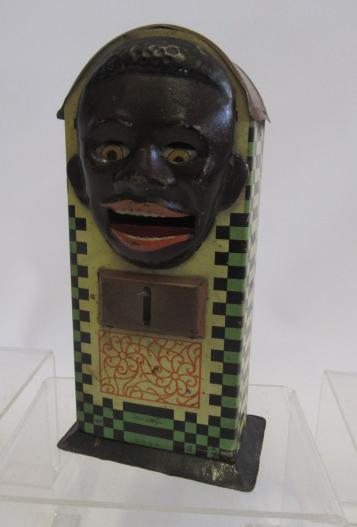 A tinplate negro head money box with lever operated tongue and eyes Image