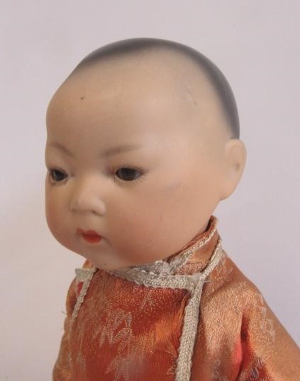 An Armand Marseille bisque head Oriental boy doll with brown glass sleeping eyes Image