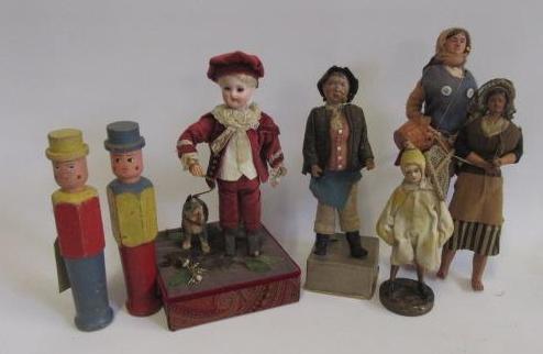 A bisque head standing boy doll on plinth with dog Image