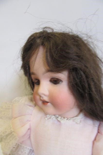 An Armand Marseille Queen Louise bisque head doll with fixed brown glass eyes Image
