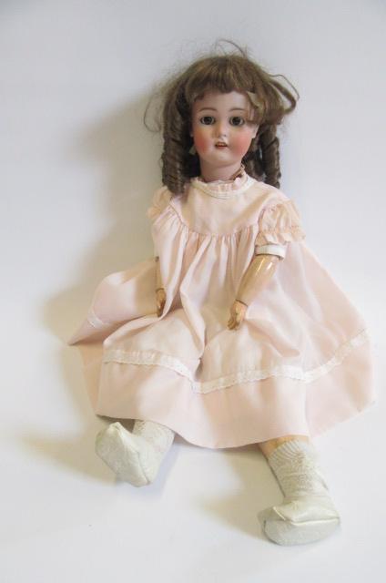 A Simon & Halbig bisque head doll with brown glass sleeping eyes Image