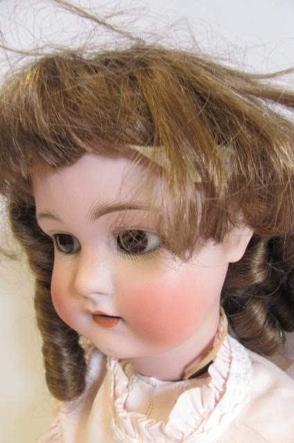 A Simon & Halbig bisque head doll with brown glass sleeping eyes Image